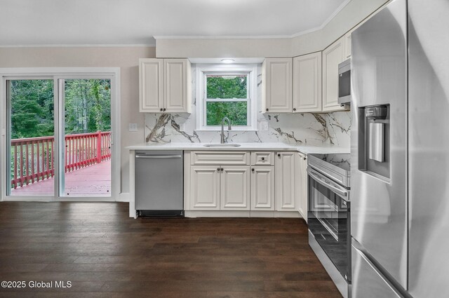 311 Old Loudon Rd, Colonie, NY 12110 - kitchen featuring appliances with stainless steel finishes, crown molding, decorative backsplash, dark wood-style flooring, and white cabinets