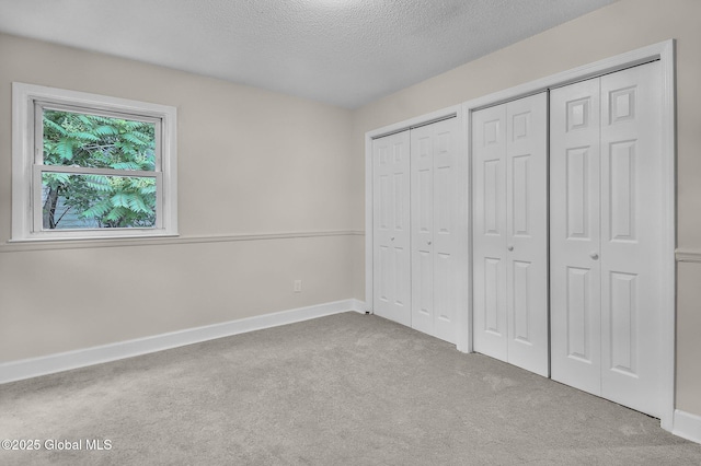 311 Old Loudon Rd, Colonie, NY 12110 - unfurnished bedroom featuring two closets, carpet floors, and a textured ceiling