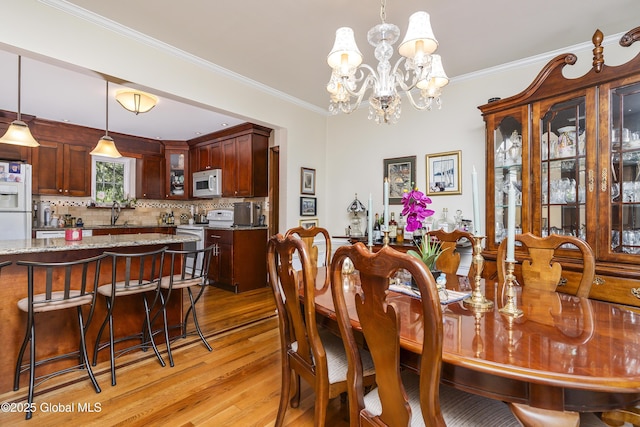 2 Eddy Ln, East Greenbush, NY 12144 - dining space with light wood finished floors, a chandelier, and crown molding