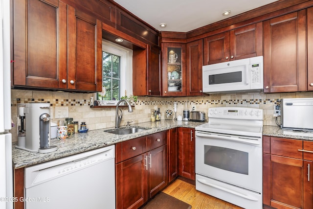 2 Eddy Ln, East Greenbush, NY 12144 - kitchen with white appliances, tasteful backsplash, light stone countertops, light wood-type flooring, and reddish brown cabinets