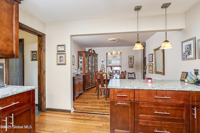2 Eddy Ln, East Greenbush, NY 12144 - kitchen featuring light wood-style floors, a chandelier, a peninsula, and light stone counters