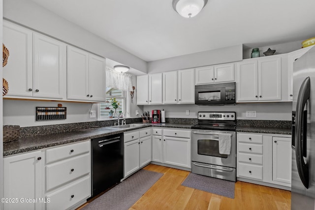 25 Mockingbird Ln, Queensbury, NY 12804 - kitchen featuring black appliances, white cabinets, light wood-type flooring, and dark countertops