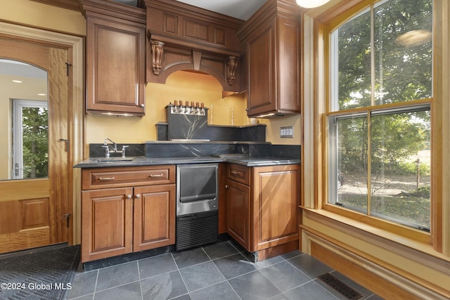 359 Wall St, Northumberland, NY 12871 - kitchen with dark countertops, brown cabinetry, arched walkways, and dark tile patterned flooring