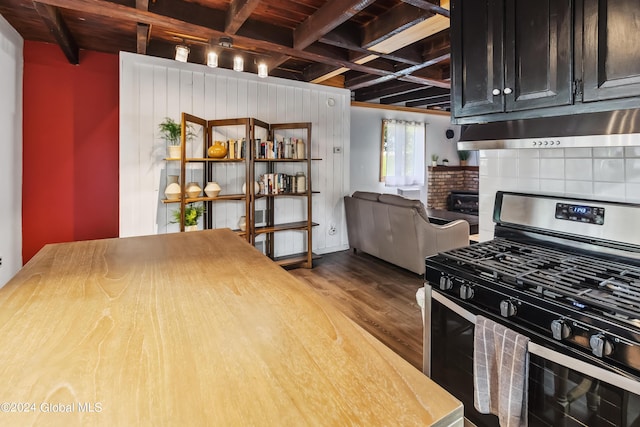 359 Wall St, Northumberland, NY 12871 - kitchen with stainless steel gas stove, under cabinet range hood, wood finished floors, a wooden ceiling with exposed beams, and dark cabinets