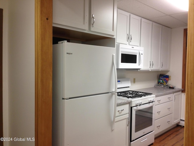 336 State Route 29, Greenwich, NY 12834 - kitchen with white appliances, white cabinetry, light countertops, wood finished floors, and a paneled ceiling