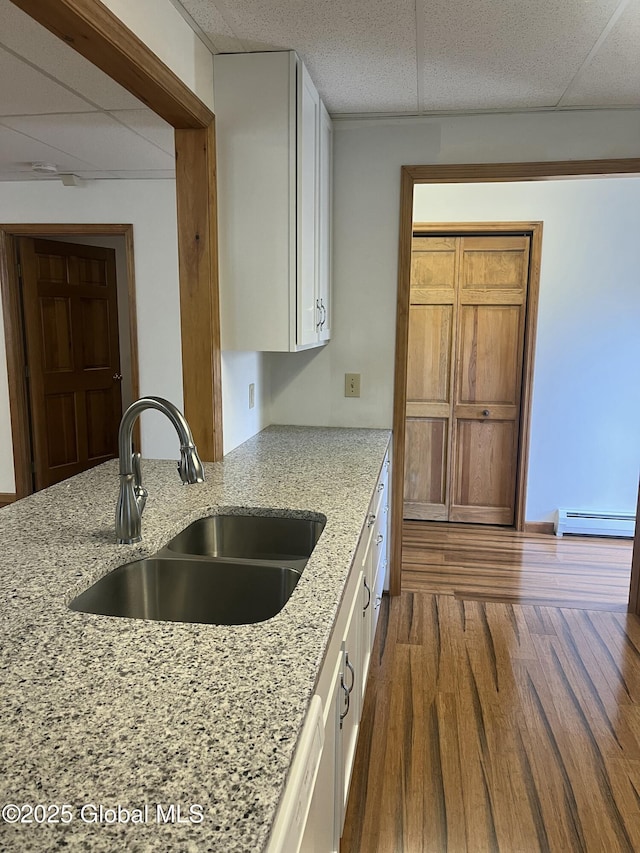 336 State Route 29, Greenwich, NY 12834 - kitchen featuring a baseboard radiator, white cabinets, a paneled ceiling, light stone counters, and dark wood-type flooring
