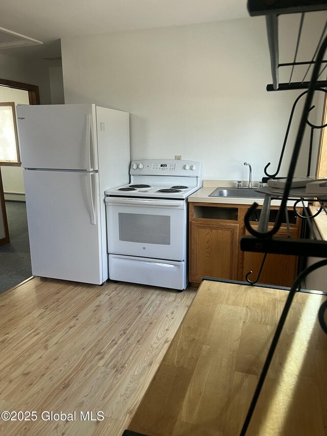 336 State Route 29, Greenwich, NY 12834 - kitchen featuring white appliances, brown cabinets, light wood-type flooring, and light countertops