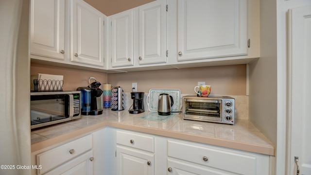 88 County Route 26a, Stuyvesant, NY 12173 - kitchen with stainless steel microwave, white cabinets, and tile countertops