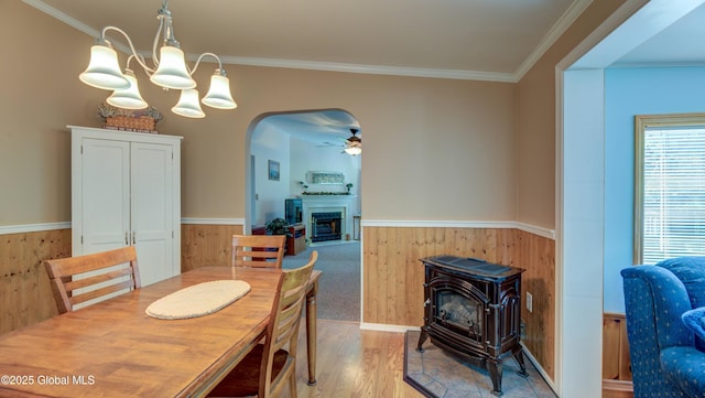 88 County Route 26a, Stuyvesant, NY 12173 - dining area featuring a wood stove, a wainscoted wall, a fireplace, wood finished floors, and wooden walls