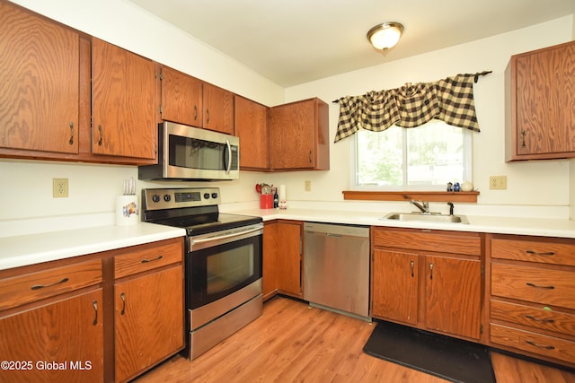 1B Scotch Mist Way, Malta, NY 12020 - kitchen featuring appliances with stainless steel finishes, light countertops, light wood finished floors, and brown cabinetry