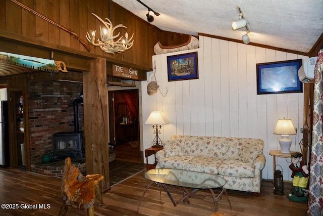 469 Military Rd, Edinburg, NY 12134 - living room with lofted ceiling, rail lighting, hardwood / wood-style floors, wooden walls, and a chandelier