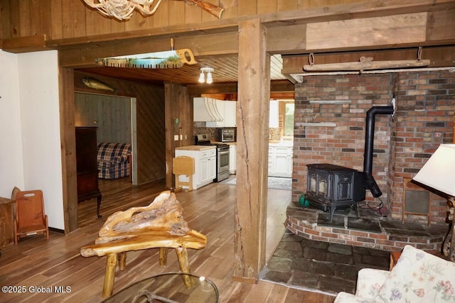 469 Military Rd, Edinburg, NY 12134 - living area with wood-type flooring, a wood stove, and wooden walls