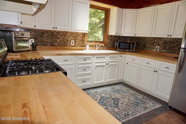 469 Military Rd, Edinburg, NY 12134 - kitchen with wood counters, extractor fan, appliances with stainless steel finishes, and tasteful backsplash