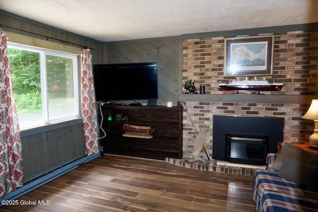 469 Military Rd, Edinburg, NY 12134 - living room featuring a textured ceiling, wood finished floors, a brick fireplace, and wood walls