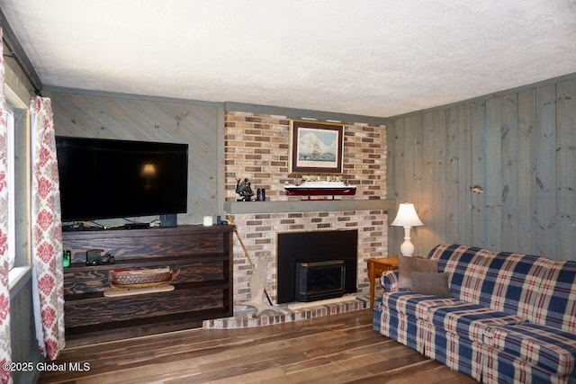 469 Military Rd, Edinburg, NY 12134 - living area featuring wood finished floors, wood walls, a textured ceiling, and a brick fireplace