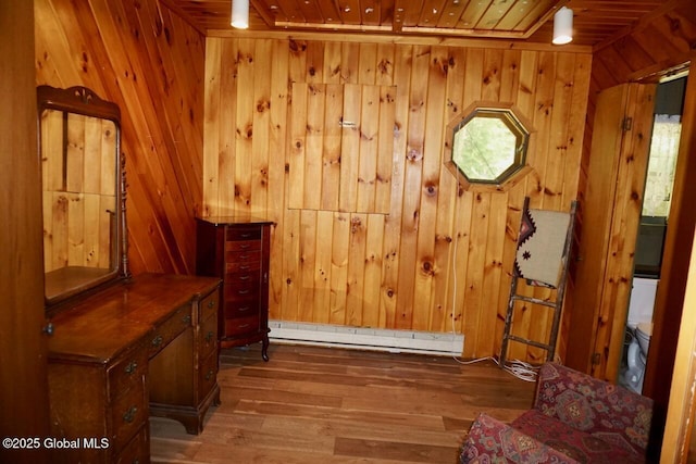 469 Military Rd, Edinburg, NY 12134 - living area with wood ceiling, wood finished floors, baseboard heating, and wooden walls