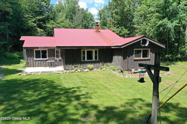 469 Military Rd, Edinburg, NY 12134 - view of front of home featuring board and batten siding, a front lawn, and a metal roof