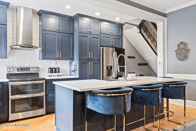 218 Lancaster St, Albany, NY 12210 - kitchen featuring stainless steel appliances, wall chimney exhaust hood, crown molding, light countertops, and a kitchen breakfast bar