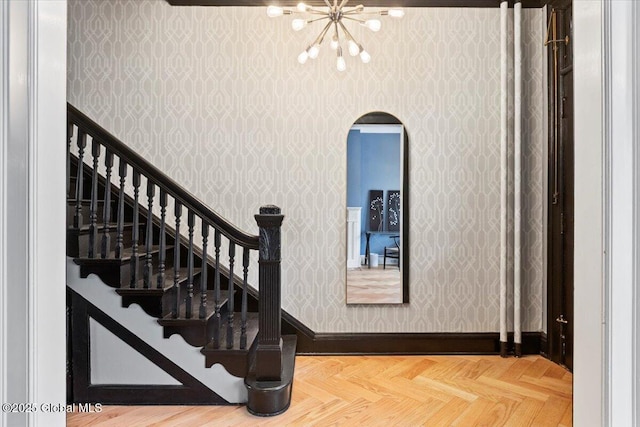 218 Lancaster St, Albany, NY 12210 - staircase with wallpapered walls, a chandelier, and arched walkways