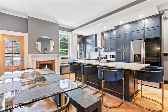 218 Lancaster St, Albany, NY 12210 - kitchen featuring stainless steel fridge, wall chimney range hood, light countertops, crown molding, and plenty of natural light