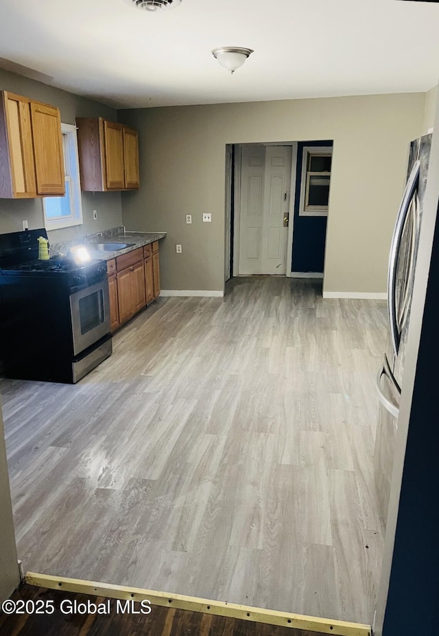 918-922 Bridge St, Schenectady, NY 12303 - kitchen with appliances with stainless steel finishes, brown cabinetry, and light wood-type flooring