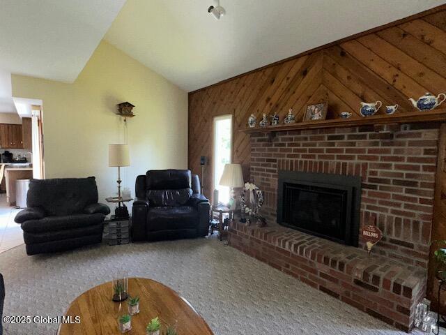 12 Bain Dr, Bethlehem, NY 12054 - carpeted living area with wooden walls, vaulted ceiling, and a brick fireplace