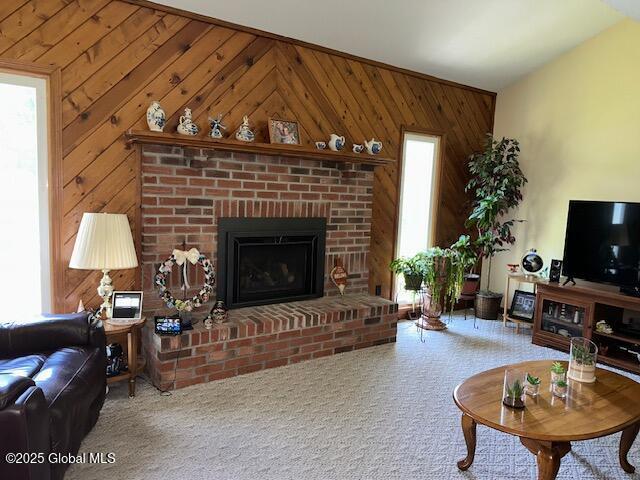 12 Bain Dr, Bethlehem, NY 12054 - living room with wooden walls, plenty of natural light, a brick fireplace, and carpet flooring
