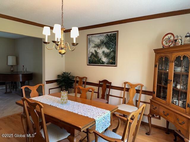 12 Bain Dr, Bethlehem, NY 12054 - dining space with ornamental molding, light wood-style floors, and a chandelier