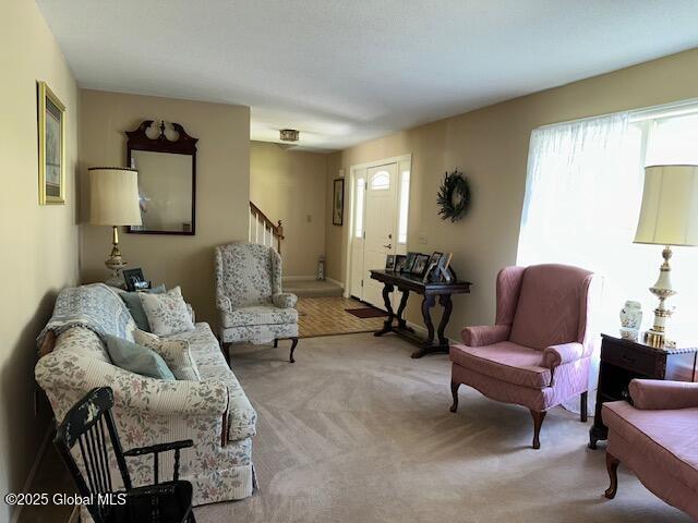 12 Bain Dr, Bethlehem, NY 12054 - living area with healthy amount of natural light, stairway, and light colored carpet