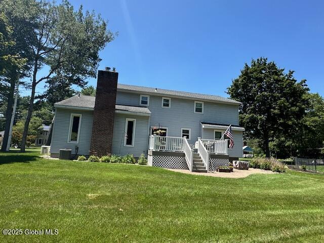 12 Bain Dr, Bethlehem, NY 12054 - rear view of house with a wooden deck, a chimney, and a yard