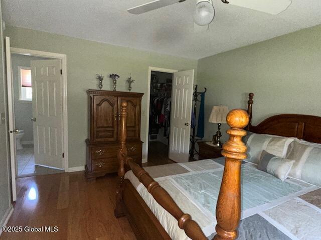 12 Bain Dr, Bethlehem, NY 12054 - bedroom with wood finished floors, a walk in closet, a closet, and a ceiling fan