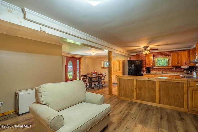 64 Coon Ln, Salem, NY 12865 - kitchen featuring black refrigerator with ice dispenser, light wood-style flooring, brown cabinetry, open floor plan, and crown molding