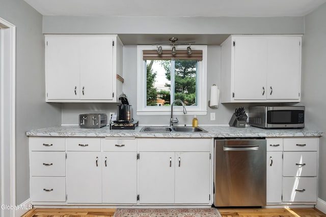 30 Crannell Ave, Bethlehem, NY 12054 - kitchen featuring appliances with stainless steel finishes, white cabinets, light wood-style floors, and light stone counters