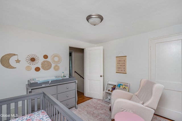 30 Crannell Ave, Bethlehem, NY 12054 - bedroom featuring wood finished floors and a crib