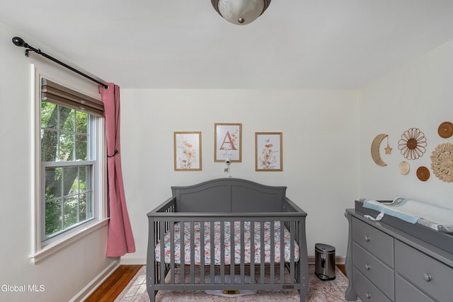 30 Crannell Ave, Bethlehem, NY 12054 - bedroom featuring a crib and wood finished floors