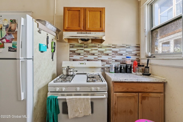 373 Delaware Ave, Albany, NY 12209 - kitchen featuring white appliances, under cabinet range hood, brown cabinetry, and tasteful backsplash