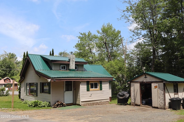 103 Seven Oaks Rd, Caroga, NY 12032 - view of front of property with a metal roof, a storage unit, and a chimney