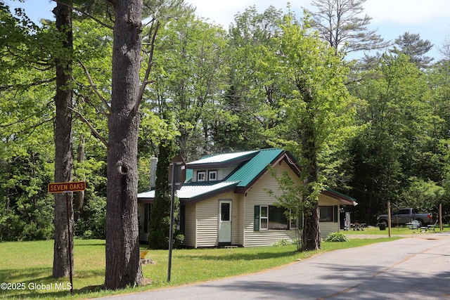 103 Seven Oaks Rd, Caroga, NY 12032 - view of front of property with a front yard, a metal roof, and driveway