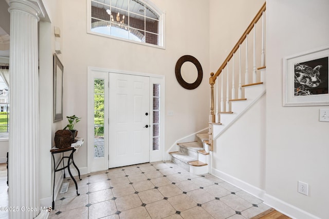 18 Beresford Rd, Clifton Park, NY 12019 - foyer entrance with a high ceiling, stairs, ornate columns, and light tile patterned flooring