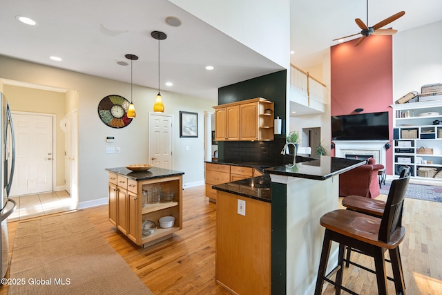 18 Beresford Rd, Clifton Park, NY 12019 - kitchen with open shelves, a ceiling fan, a peninsula, a kitchen bar, and light wood finished floors