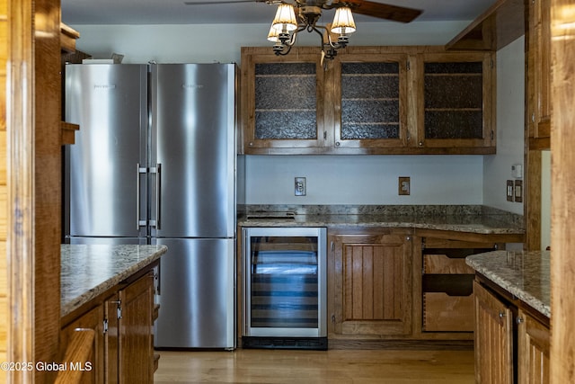 8 Burning Bush Blvd, Clifton Park, NY 12019 - kitchen with high end refrigerator, beverage cooler, brown cabinets, glass insert cabinets, and light wood-style flooring