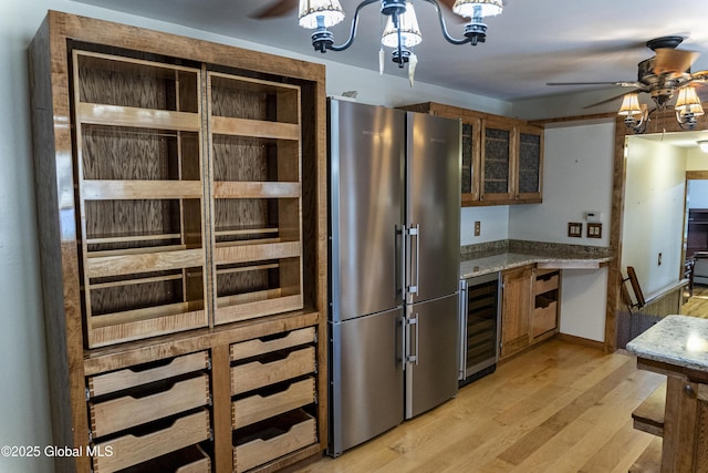 8 Burning Bush Blvd, Clifton Park, NY 12019 - kitchen featuring high end refrigerator, wine cooler, a ceiling fan, light wood-style flooring, and a chandelier