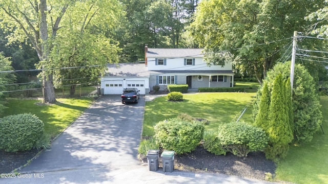 8 Burning Bush Blvd, Clifton Park, NY 12019 - traditional-style home with asphalt driveway, a garage, a front yard, and a chimney