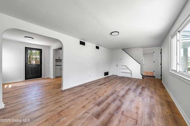 2095 Fiero Ave, Rotterdam, NY 12303 - unfurnished living room with stairway, light wood finished floors, and arched walkways