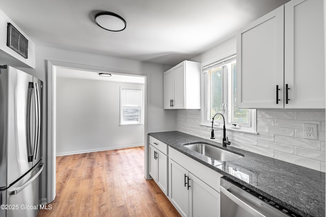 2095 Fiero Ave, Rotterdam, NY 12303 - kitchen featuring appliances with stainless steel finishes, backsplash, dark stone countertops, light wood-type flooring, and white cabinets
