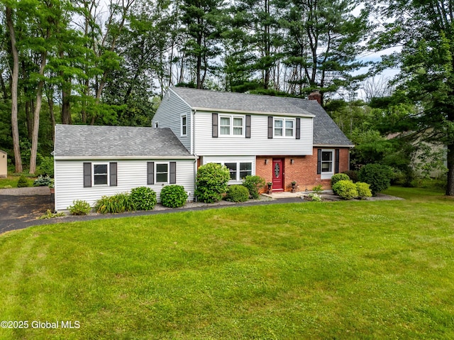 973 Avon Crest Blvd, Niskayuna, NY 12309 - colonial-style house with a chimney, a front yard, brick siding, and a shingled roof