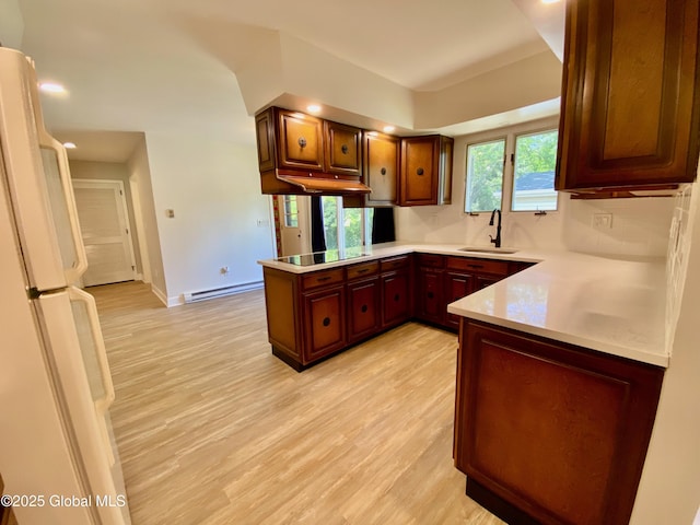 3 Olcott Ln, East Greenbush, NY 12144 - kitchen featuring freestanding refrigerator, a peninsula, light countertops, light wood finished floors, and decorative backsplash