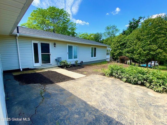 3 Olcott Ln, East Greenbush, NY 12144 - back of house featuring roof with shingles and a patio area