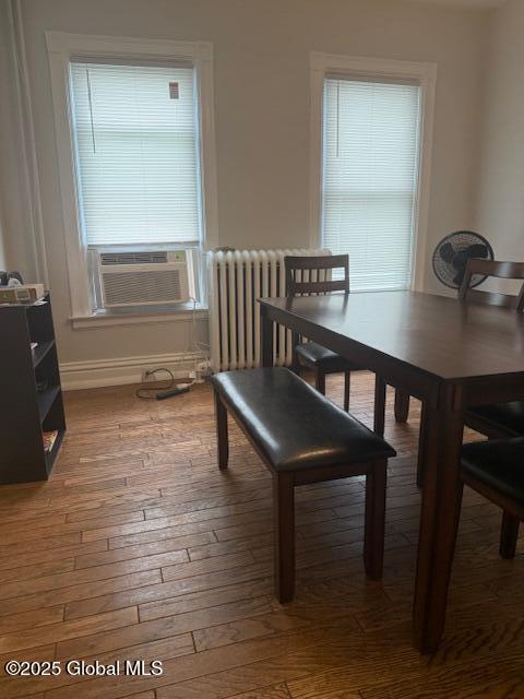 527 Pawling Ave, Troy, NY 12180 - dining area featuring radiator, healthy amount of natural light, cooling unit, and wood-type flooring