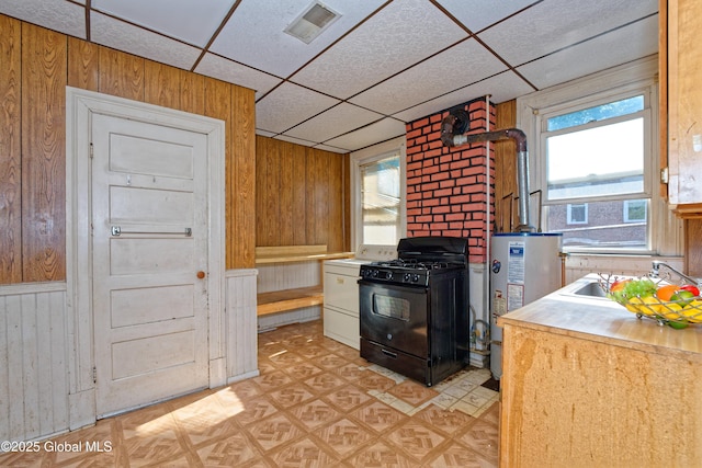 850 Peoples Ave, Troy, NY 12180 - kitchen with gas stove, wood walls, water heater, light flooring, and a drop ceiling